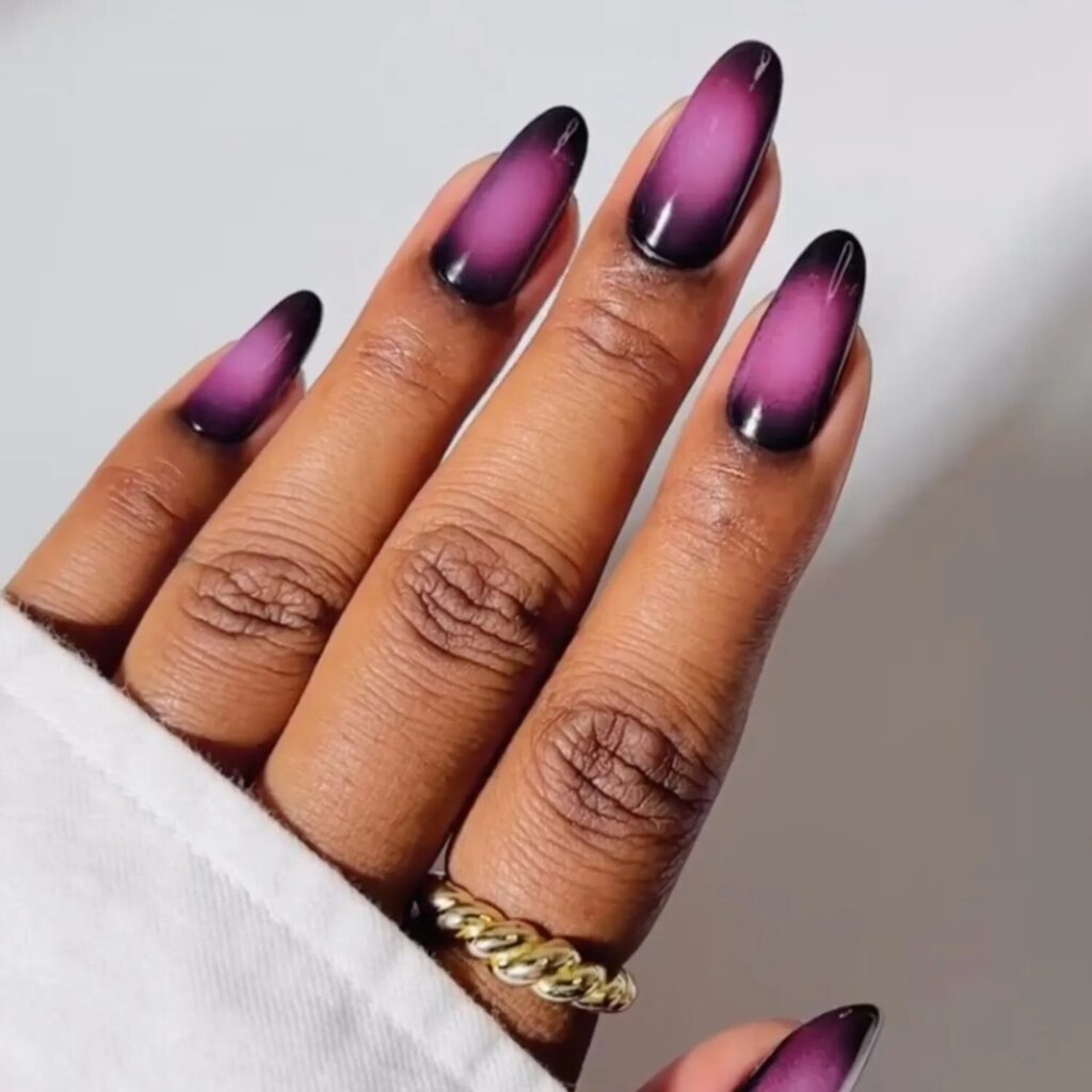 Moody plum and black aura nails reflecting light with a mystical, celestial vibe