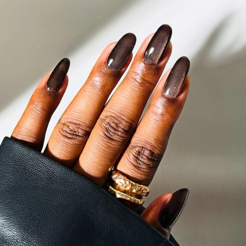 Dark gray velvet nails with hints of ember shimmer capturing a smoky fall aesthetic