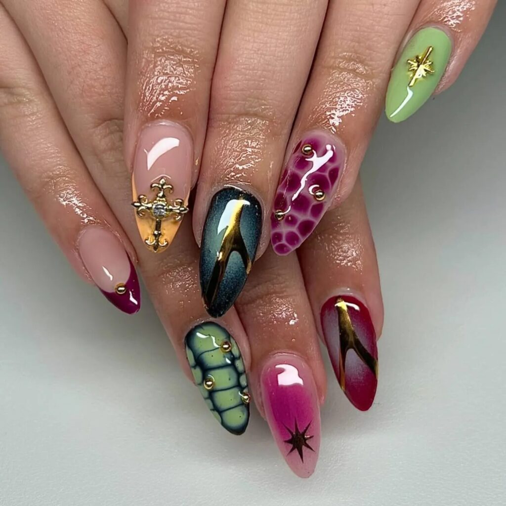 Luxurious jewel-toned nails with gold metallic detailing and aura-style finishes