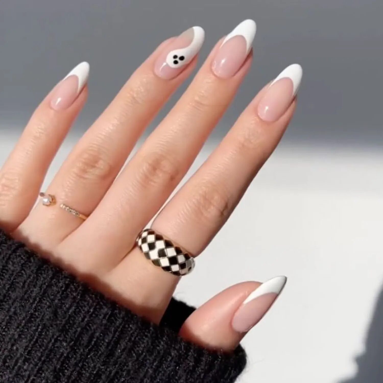 Minimalist white French nails with tiny ghost face accent for subtle Halloween manicure.