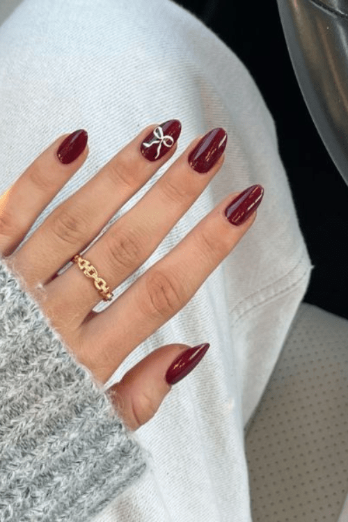 Red wine nails with a single bow accent