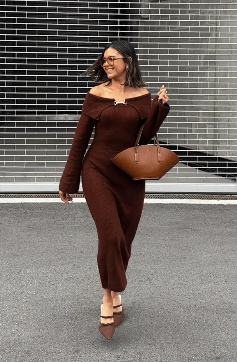 Woman in a form-fitting chocolate brown knit top and matching accessories, creating a bold knit moment.