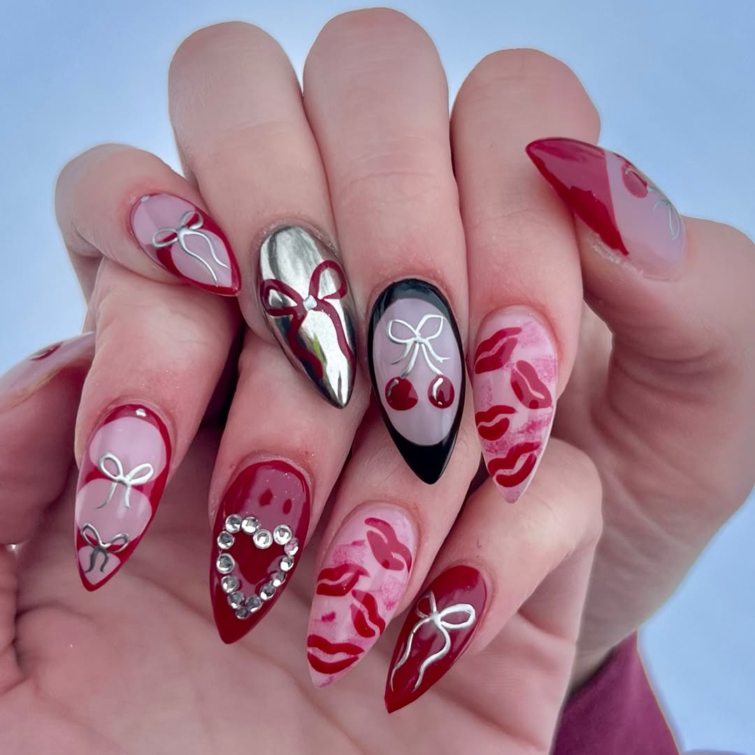 Deep red and metallic chrome nails with bows and kiss accents