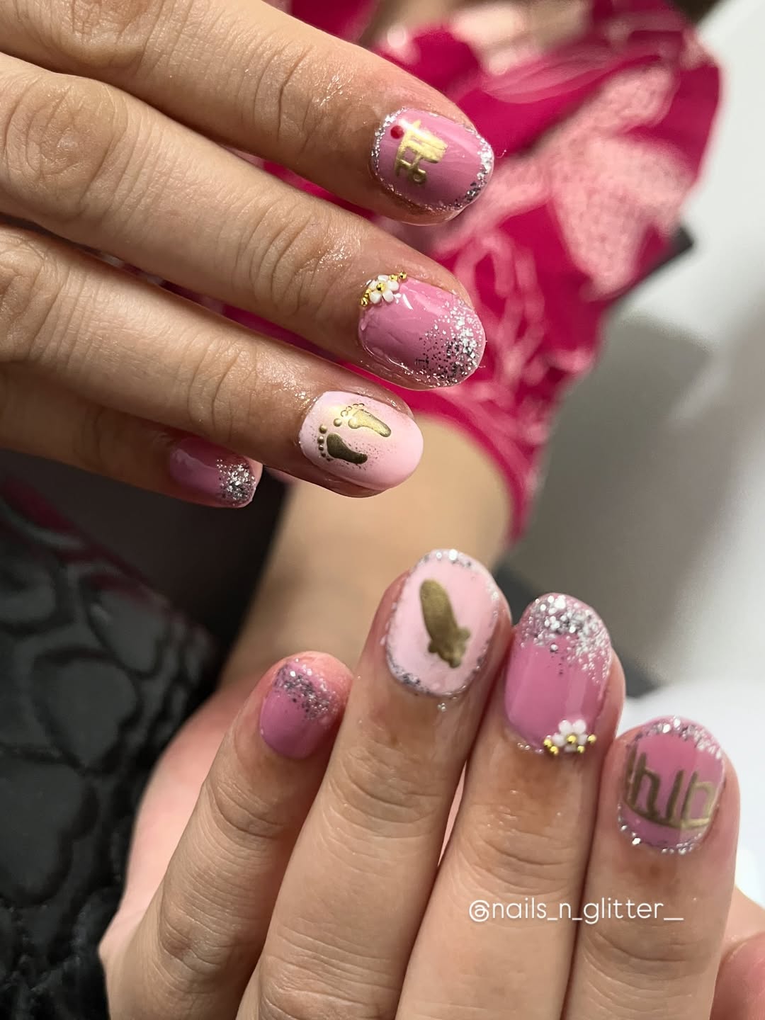 Pink and gold glitter nails with raised golden footprints