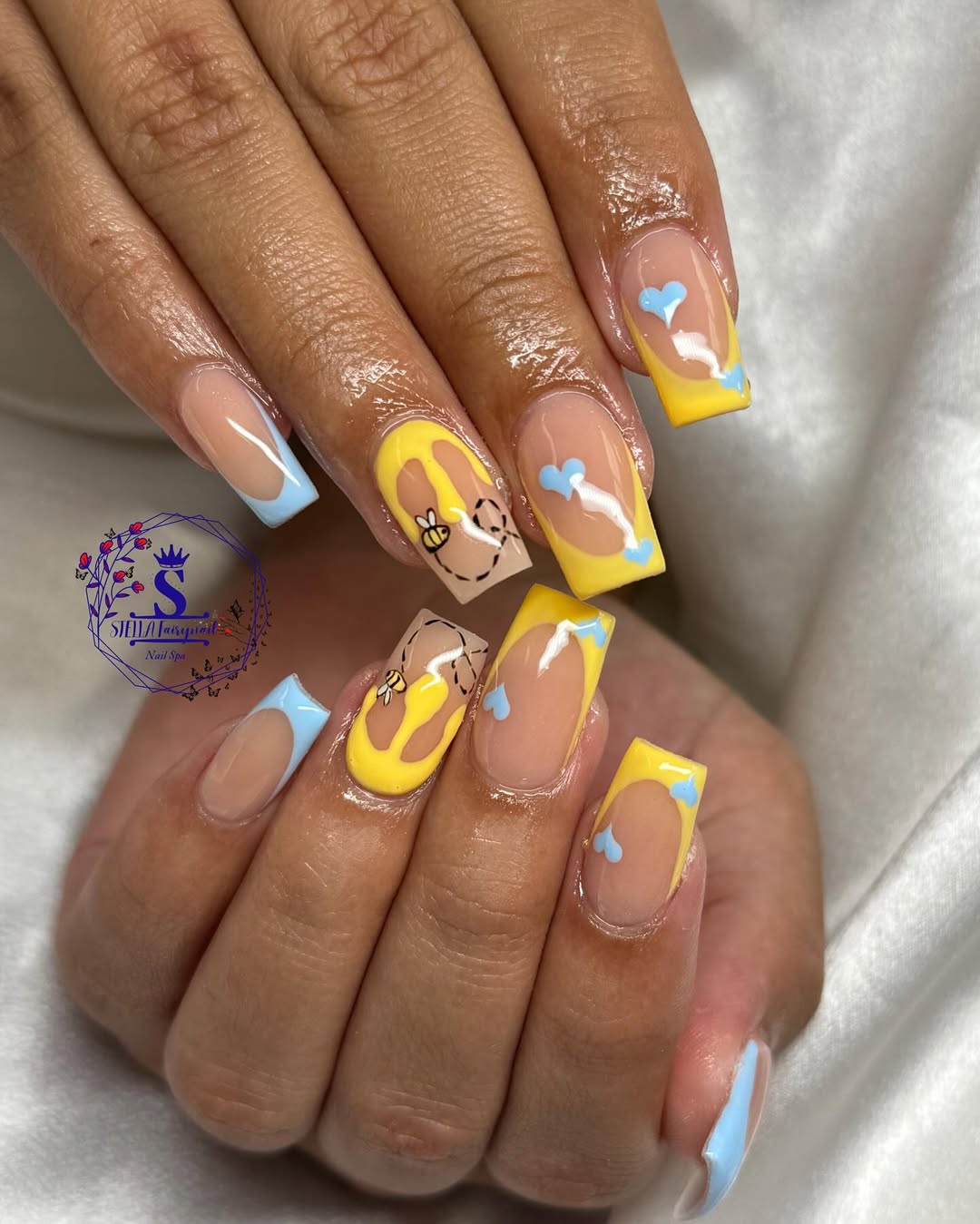 Yellow honey drip nails with blue baby hearts and bees