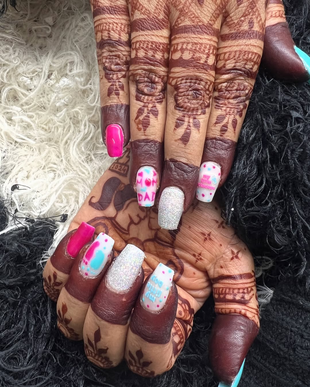 Bright pink and silver glitter nails with 'MOM' and 'DAD' text