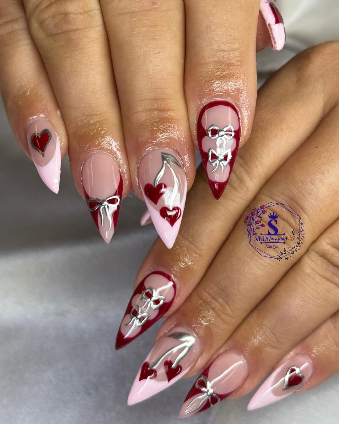 Soft pink nails with metallic touches and heart motifs