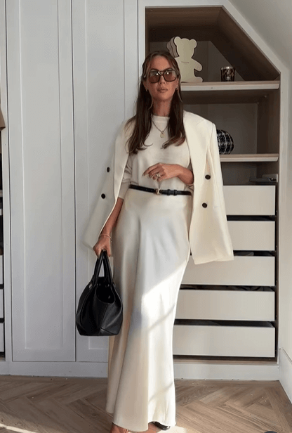 Woman in an all-cream outfit with clean lines and soft draping, showcasing quiet luxury.