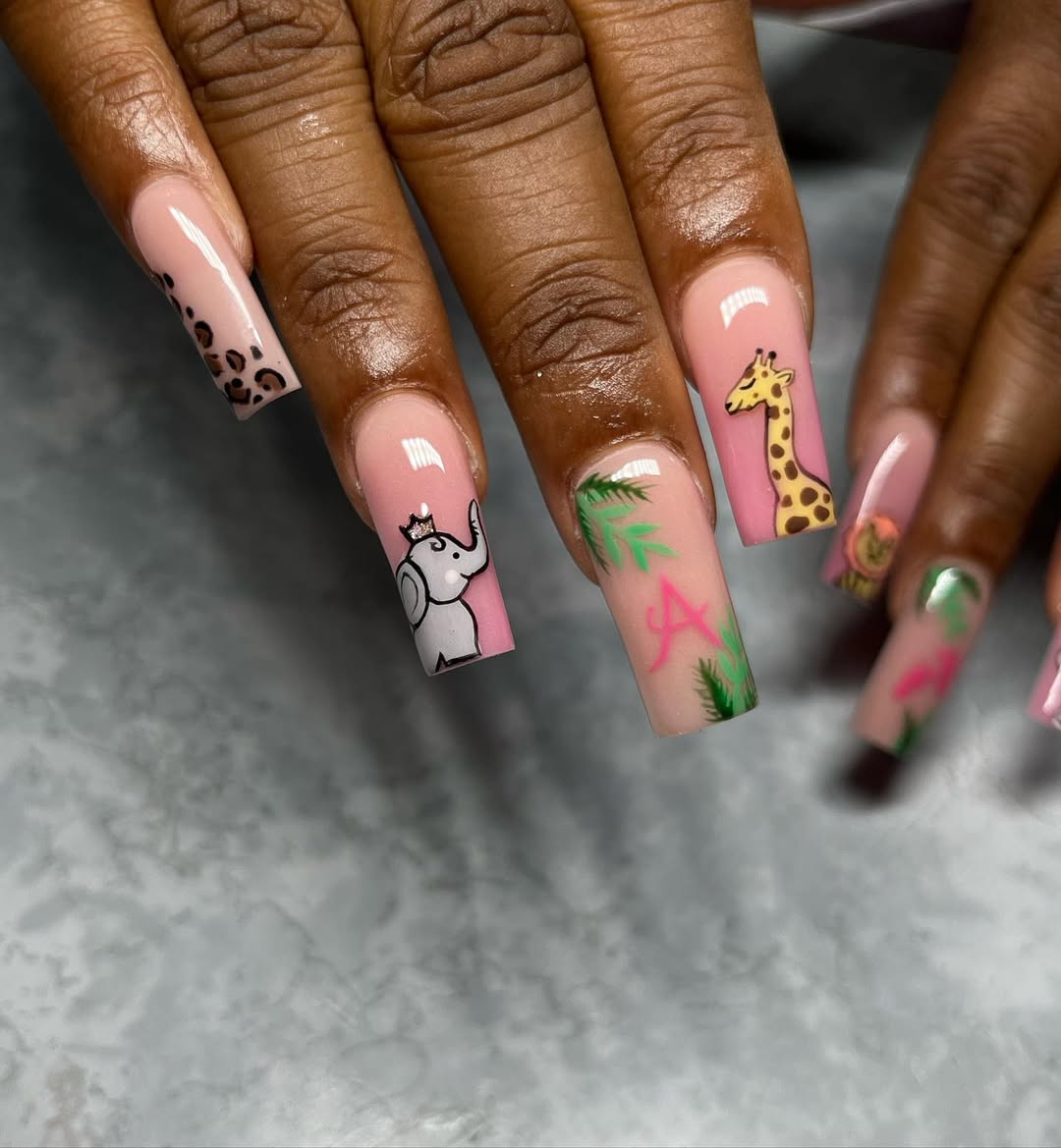 Blush pink nails with safari animals, crowns, and leafy accents