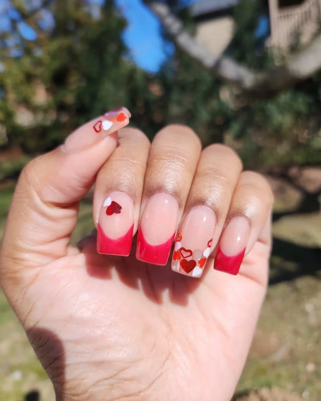 Classic French tips with tiny hearts and rosy tones