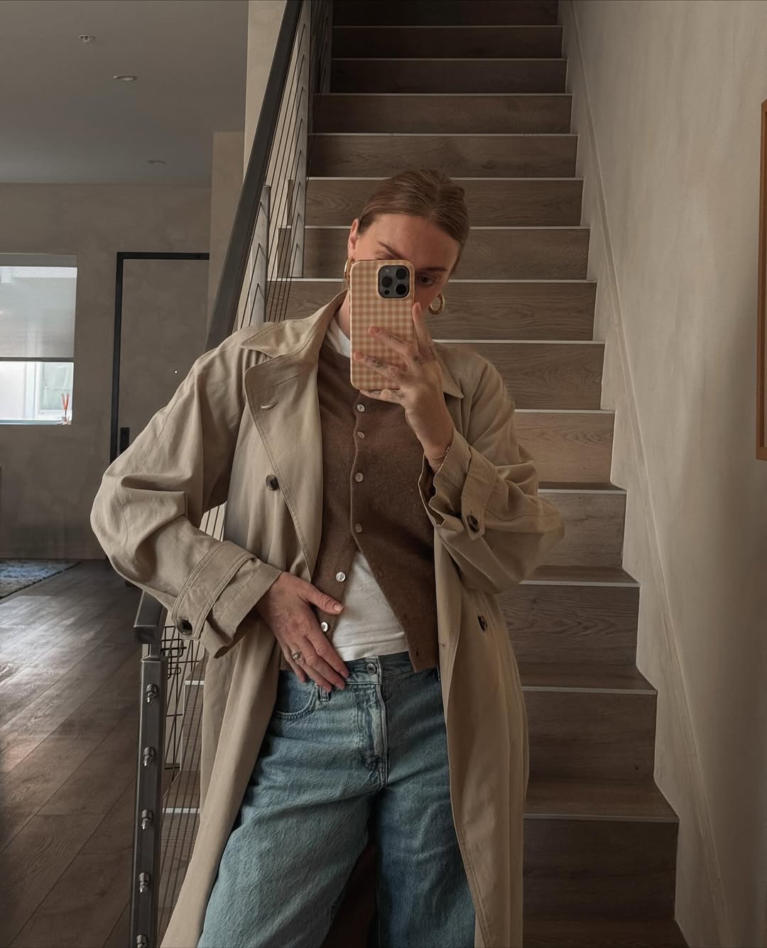 An effortless outfit in soft neutrals combining a trench, layers, and denim.