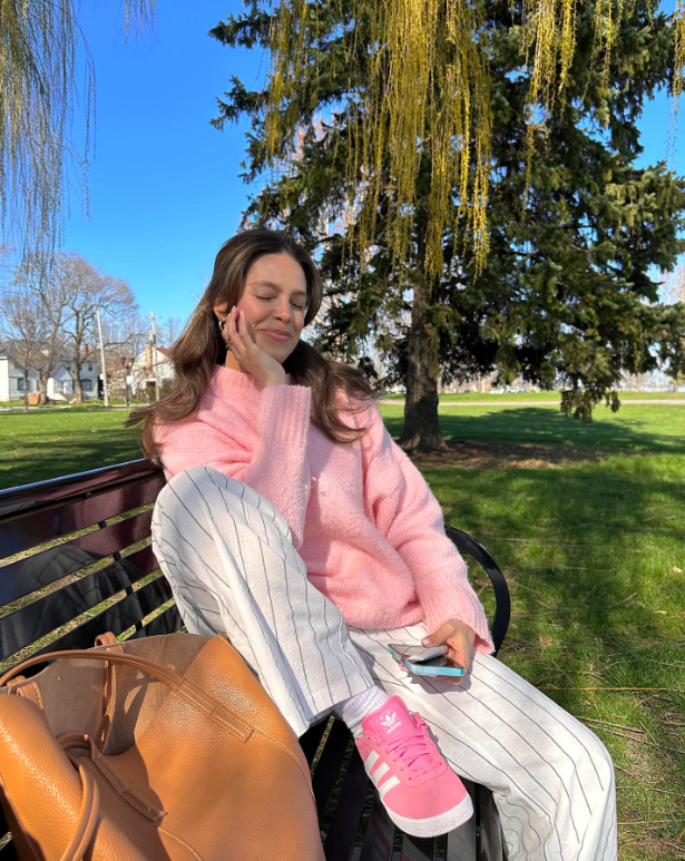 A pastel sweater paired with striped pants.