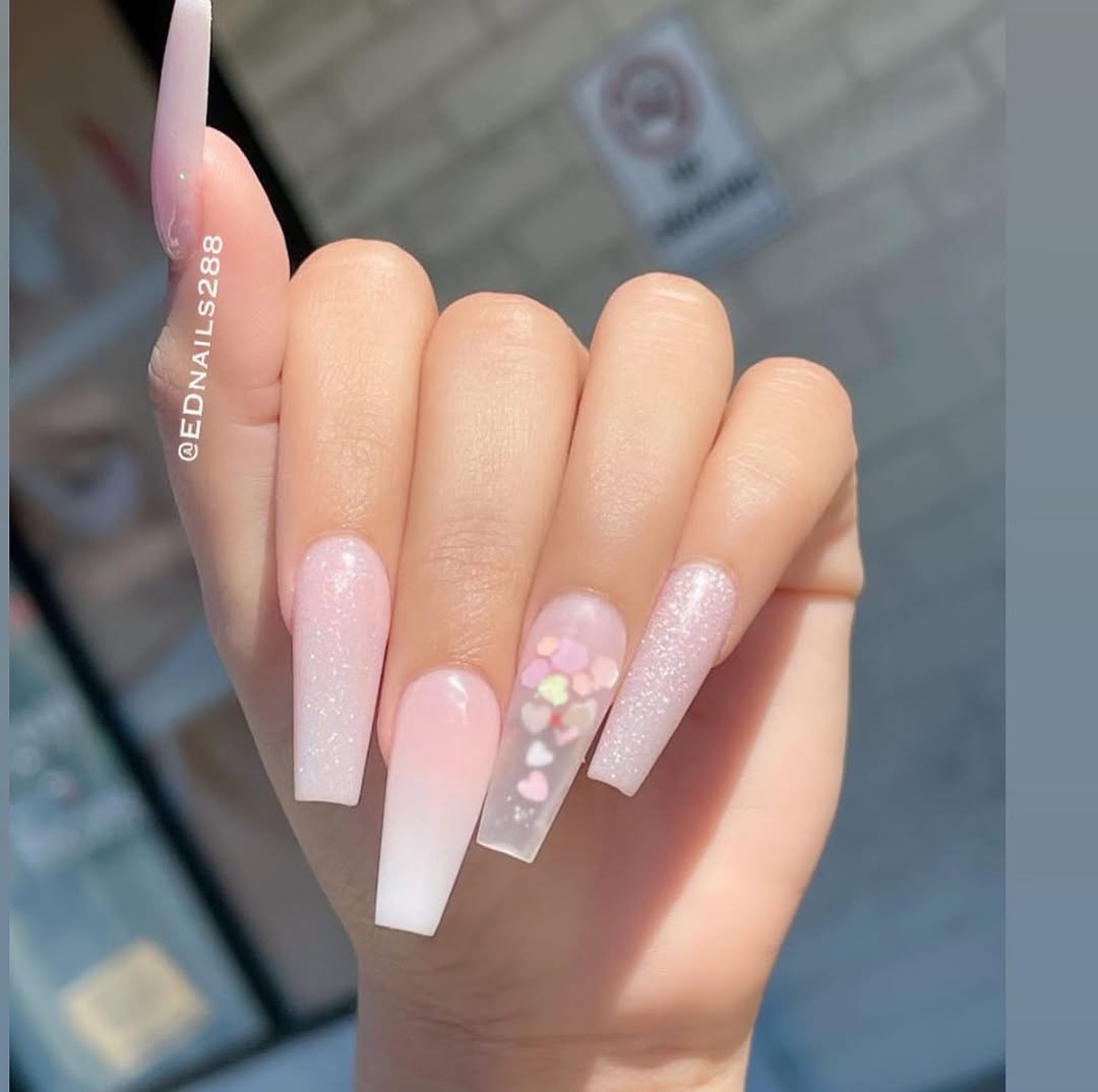 Milky pink nails with subtle shimmer and embedded hearts