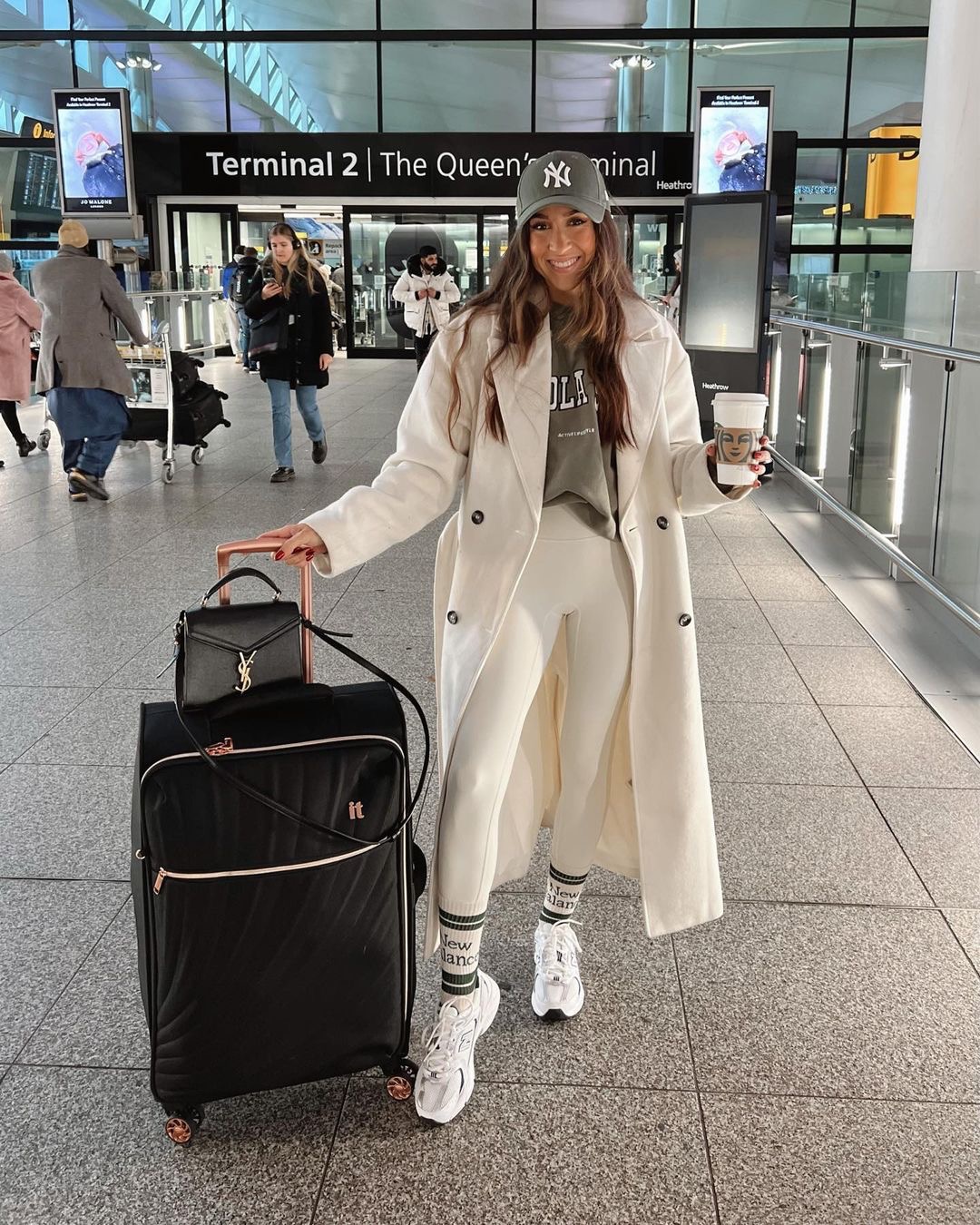 Sporty and luxe airport outfit with a monochrome base and long coat.