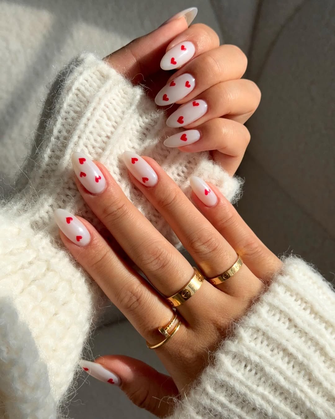 Minimalist white nails with tiny red hearts for Valentine's Day