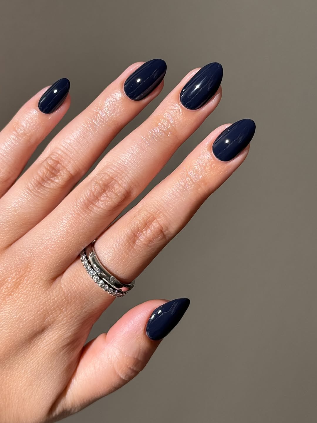 Deep navy gloss nails with a short almond shape.