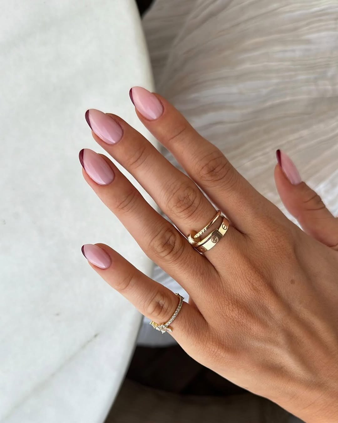 Sheer pink nails with thin burgundy outlines
