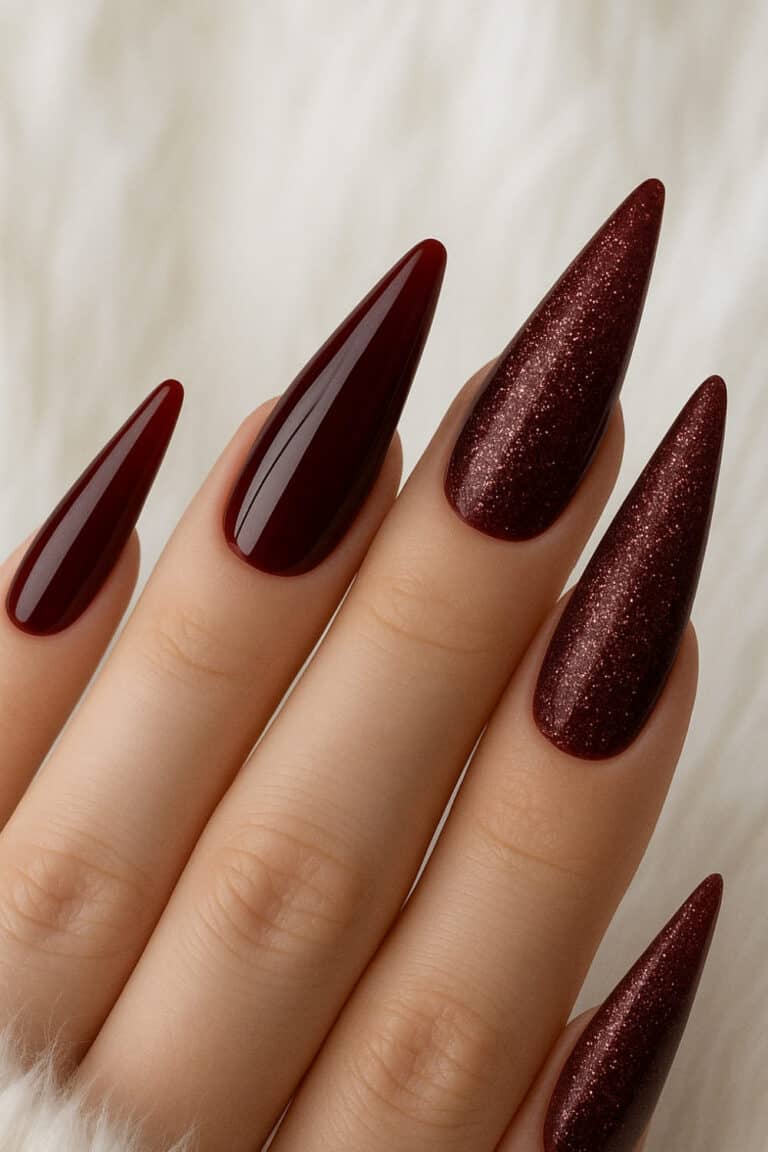 Glossy deep wine red nails with matching dark glitter accents