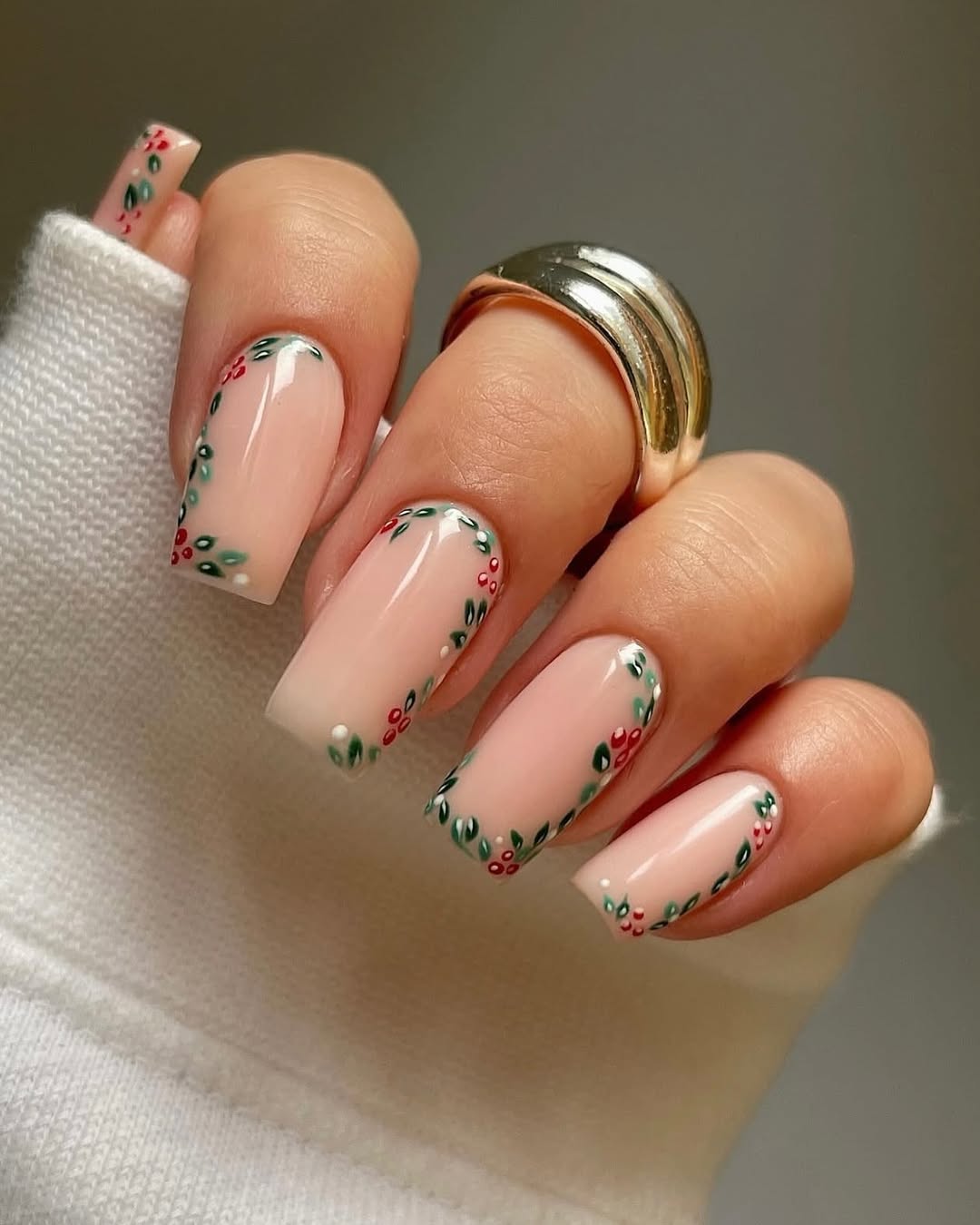 Nude nails with French tips delicately bordered by tiny holly leaves and berries.