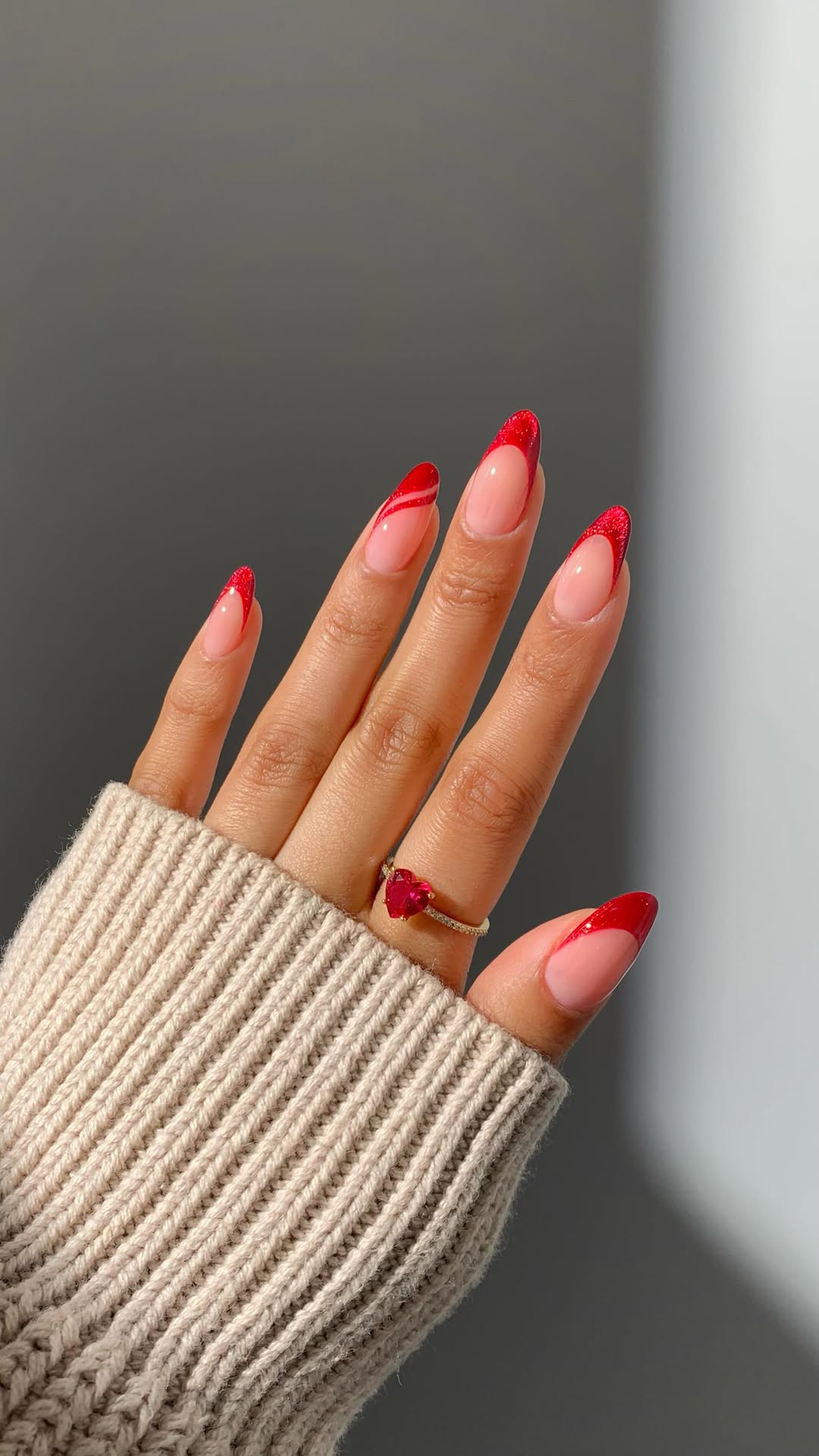 Bright red glitter French tips with glossy red swirl accents