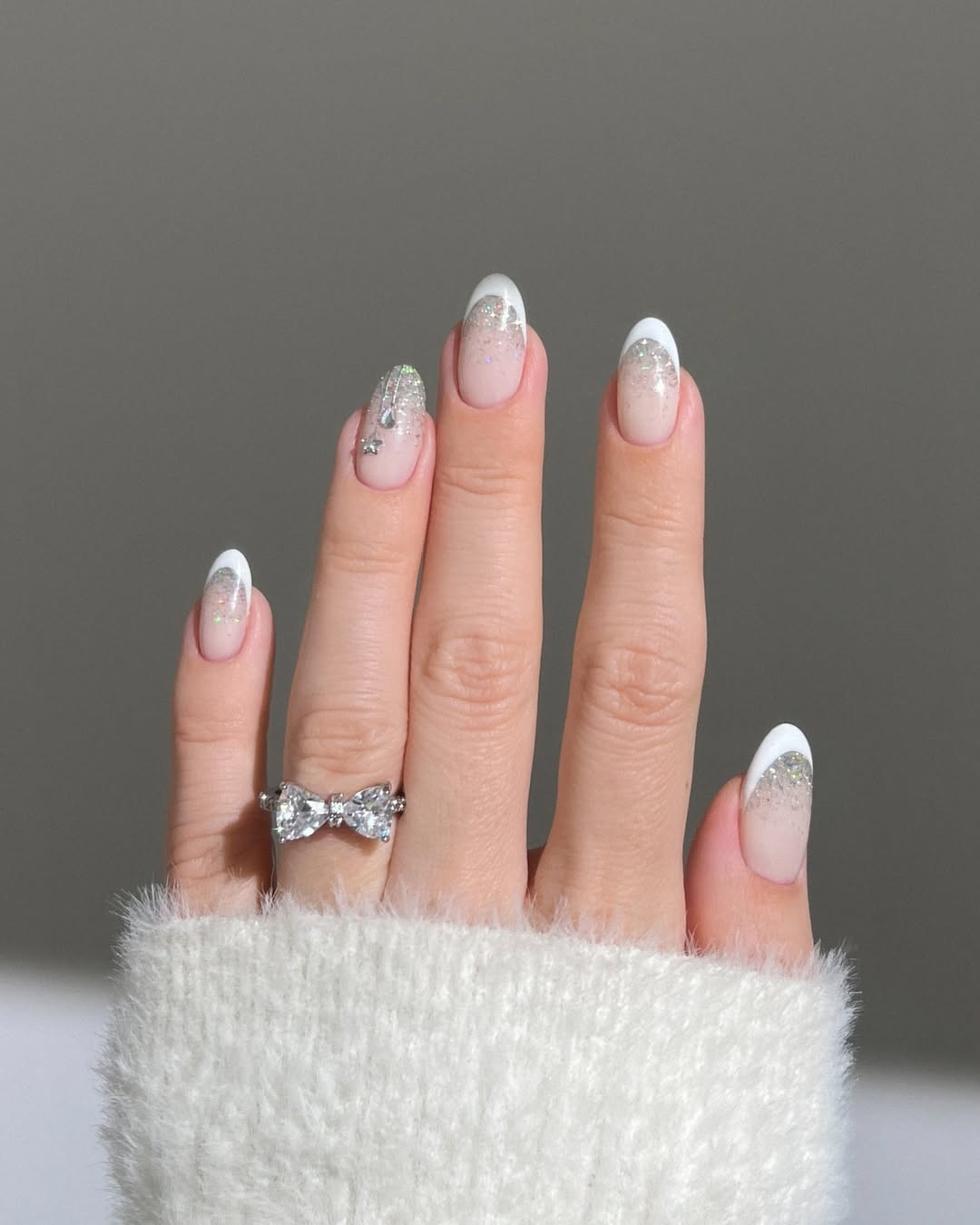 White French tips fading into silver glitter for a frosted look