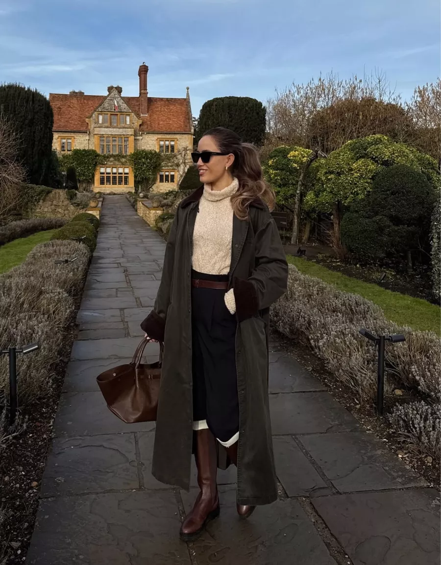 Waxed coat, cream turtleneck, dark skirt, and riding boots