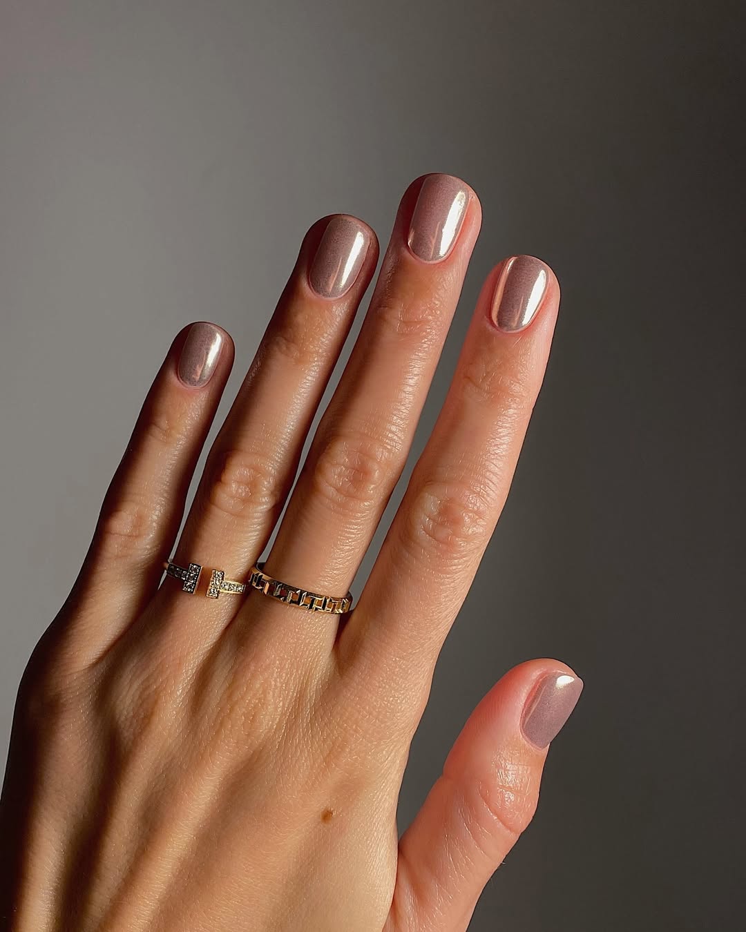 Rose gold shimmer nails with a short rounded shape.