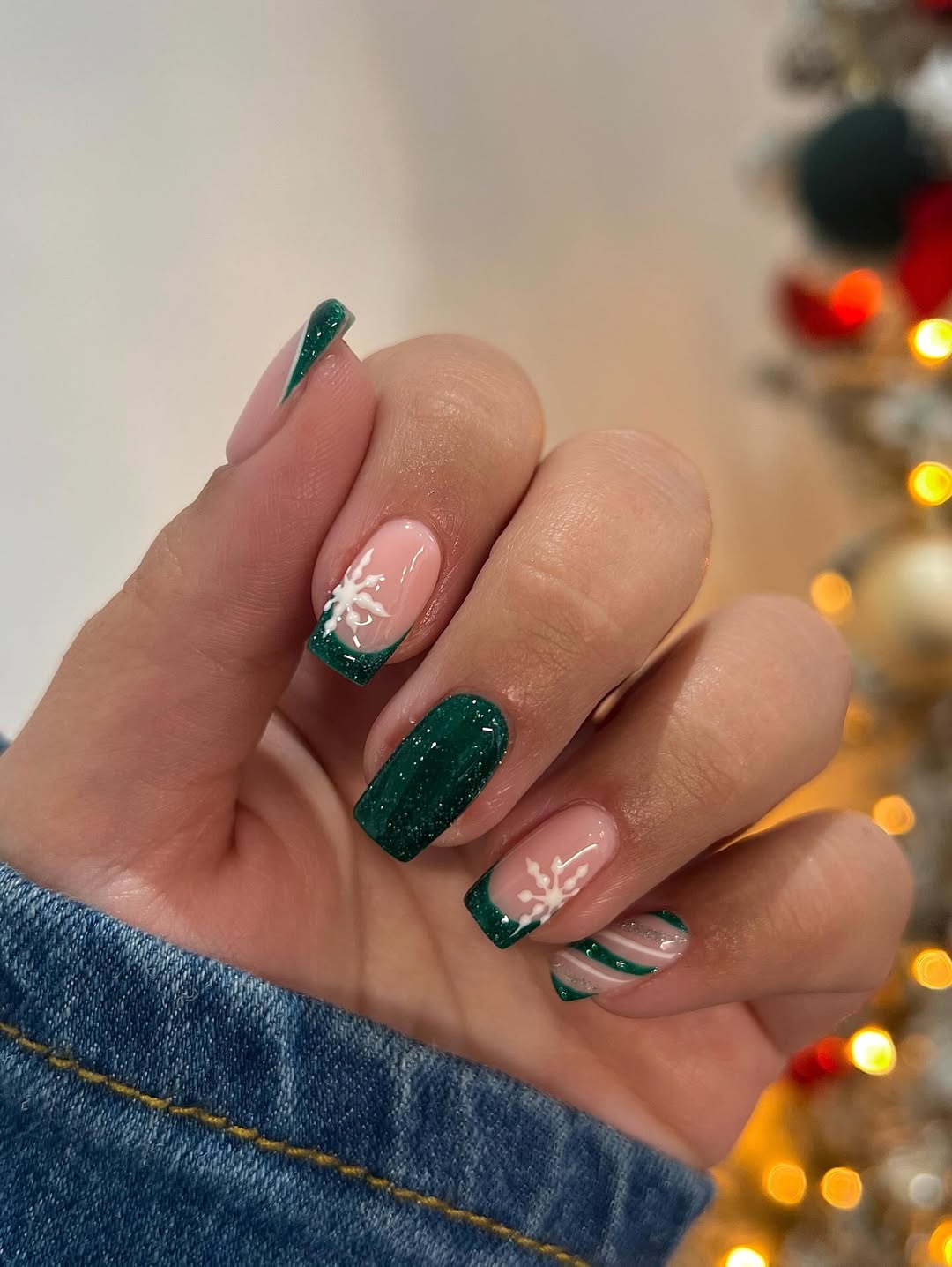 Emerald green glitter with French tips and soft white snowflakes.