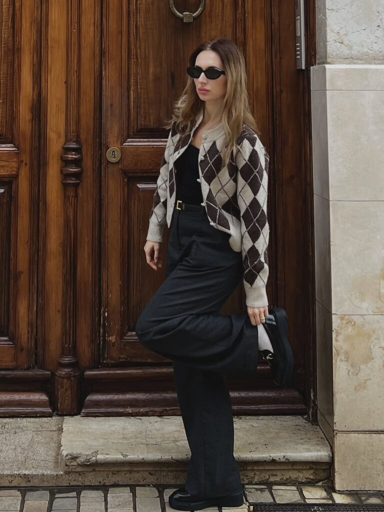 Argyle cardigan with tailored trousers, loafers, and white socks.