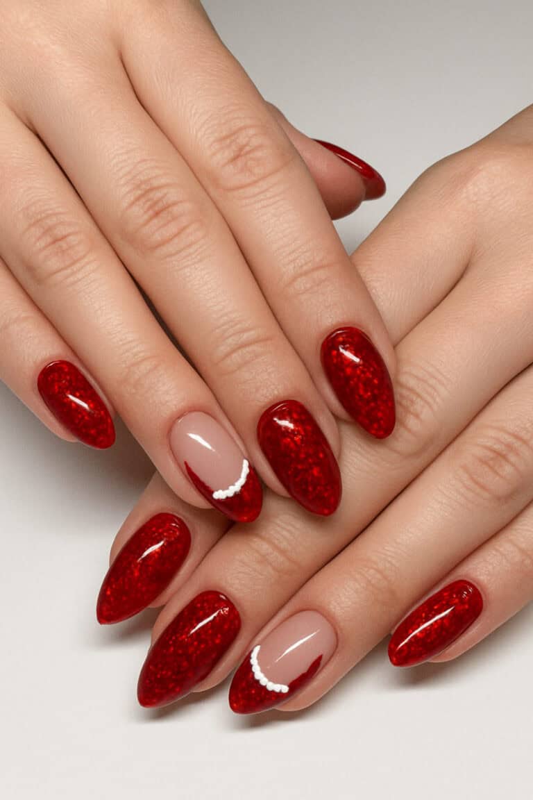 Sparkling bold red nails with soft nude accent nails featuring a curved white detail.