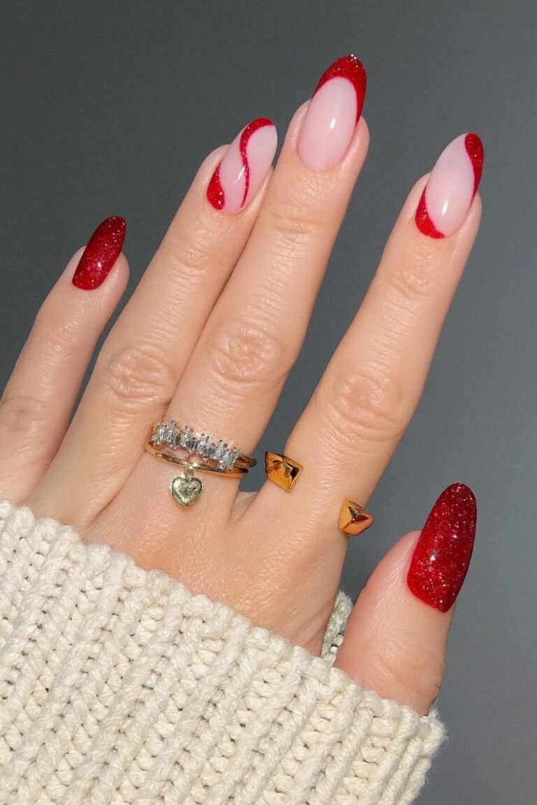 Sparkly cherry red and soft pink nail design with curved red lines resembling candy cane swirls.