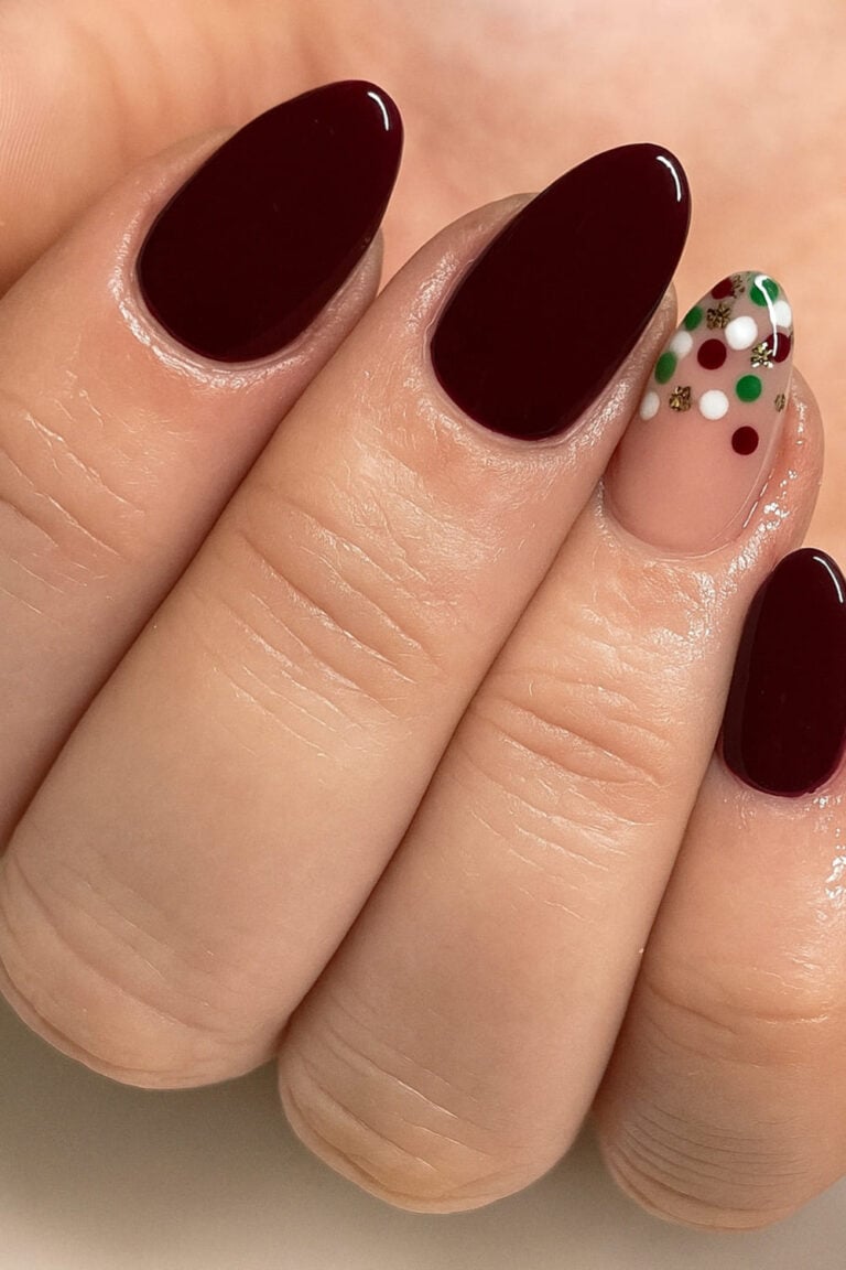 Glossy mocha-red nails with a playful confetti accent nail