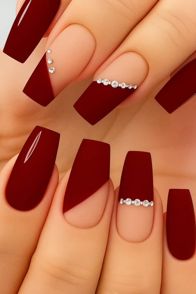 Bold matte deep red nails with nude base and crystal accents