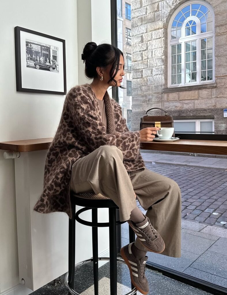 Leopard print cardigan with taupe wide-leg trousers and sneakers.