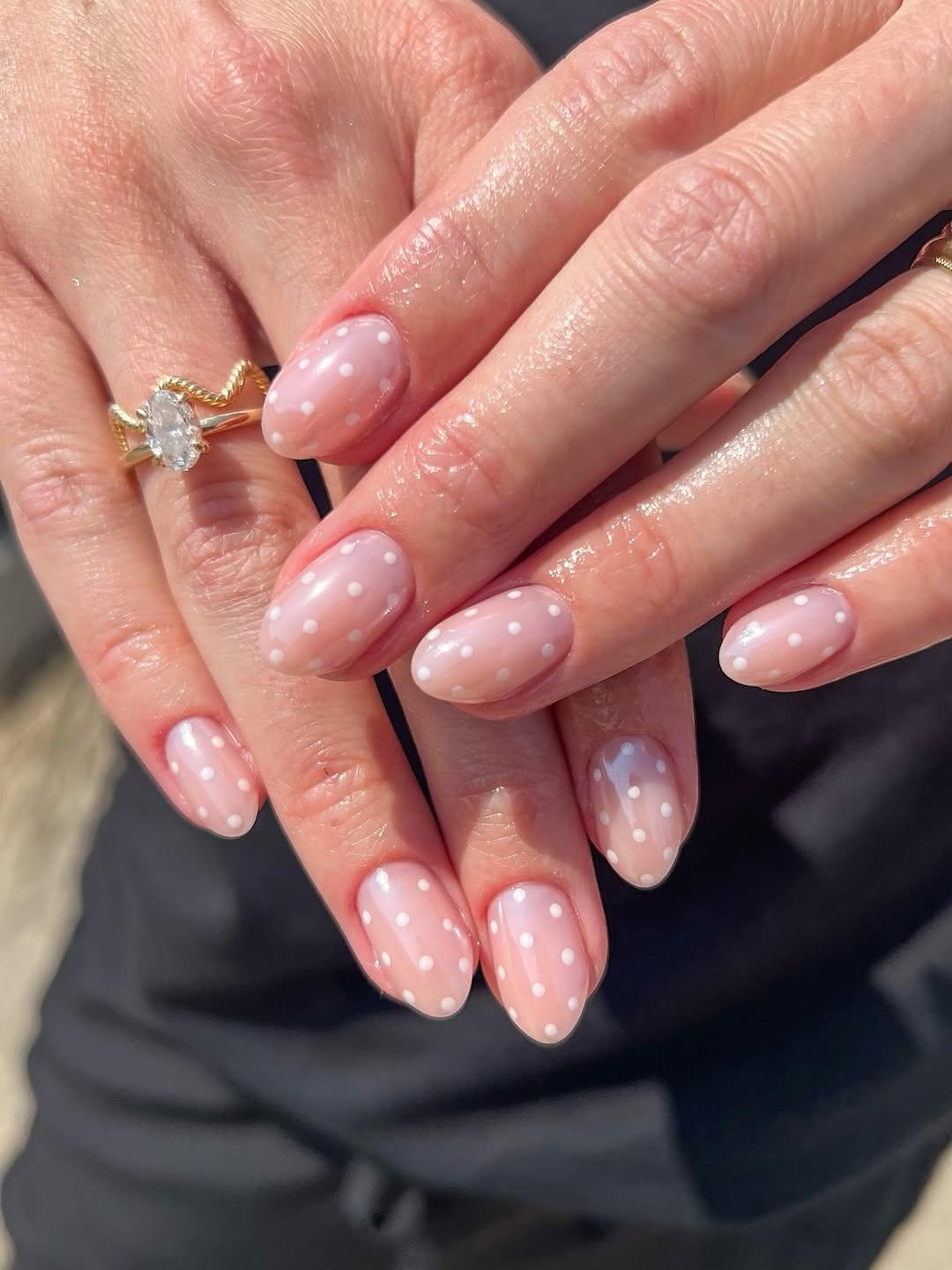 Sheer pink nails with subtle white polka dots
