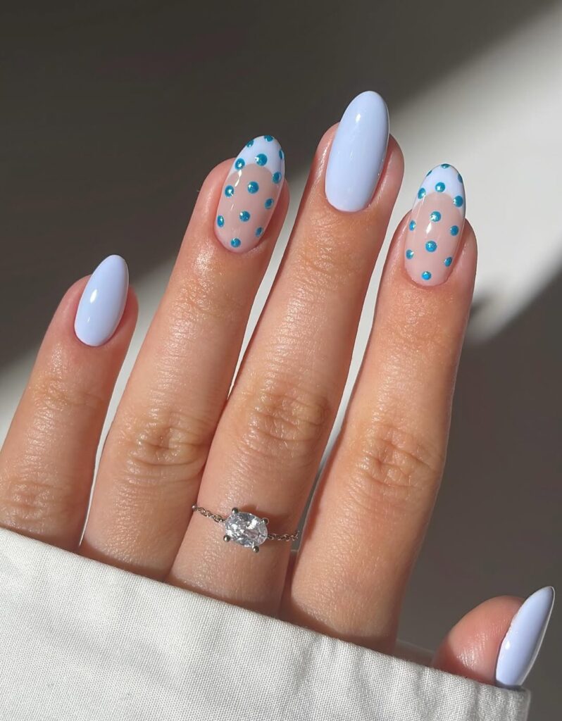 Soft icy blue nails with playful teal polka dots.