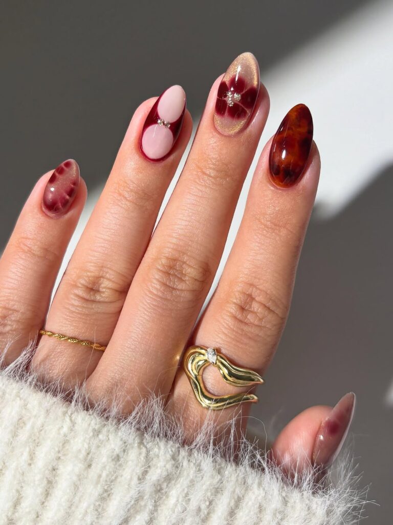 Deep berry tones with tortoise accents and petal shapes.