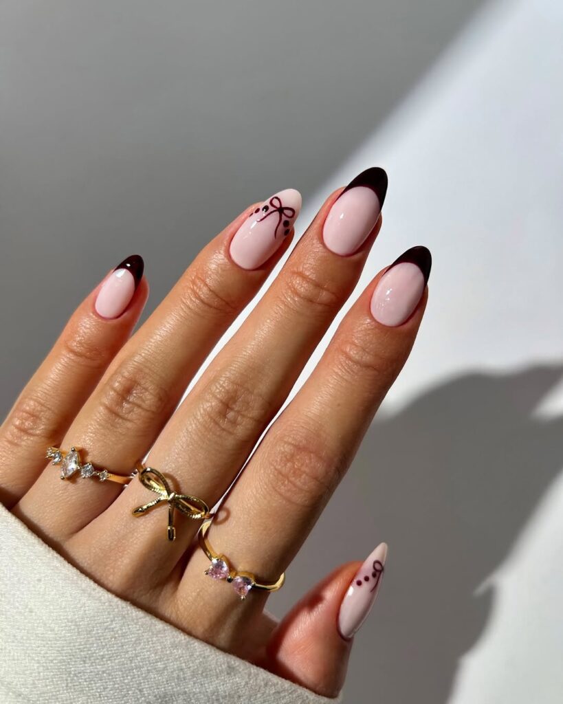 Deep berry French tips with subtle pink polish and tiny bow accents.