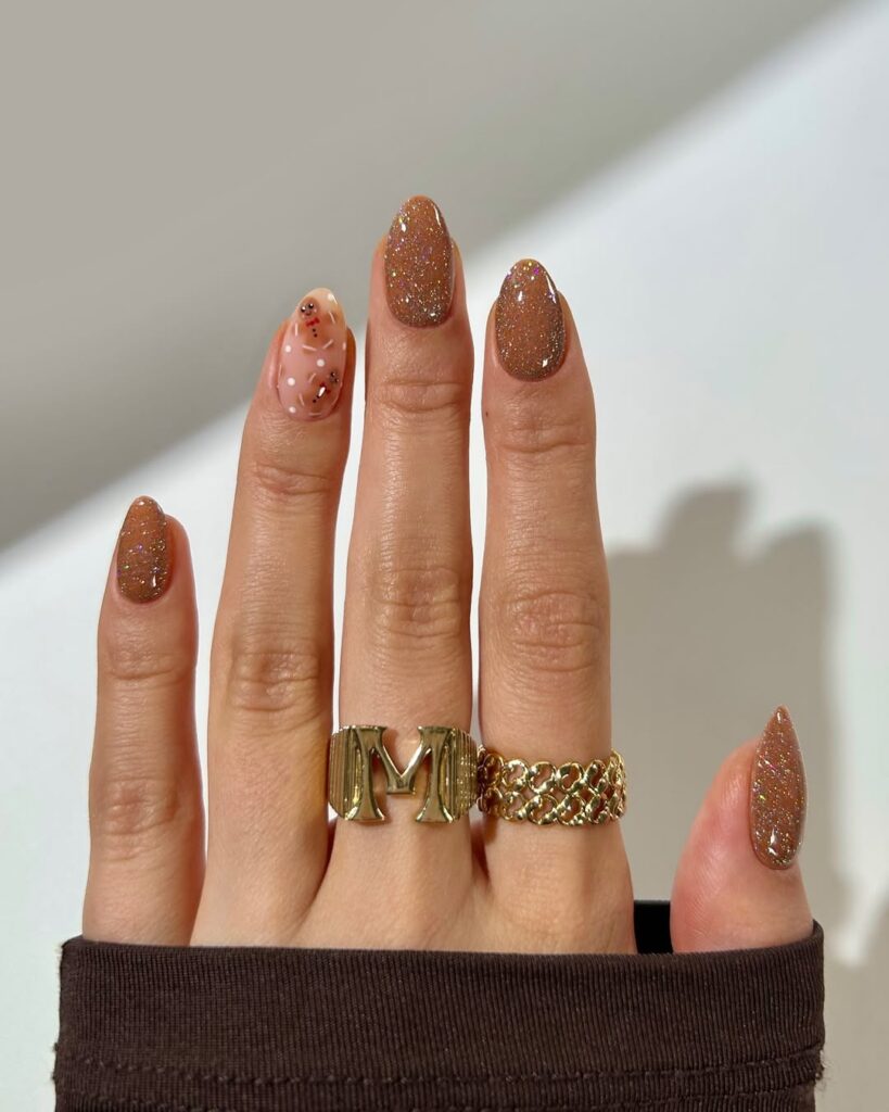 Warm brown glitter nails with a small gingerbread accent.