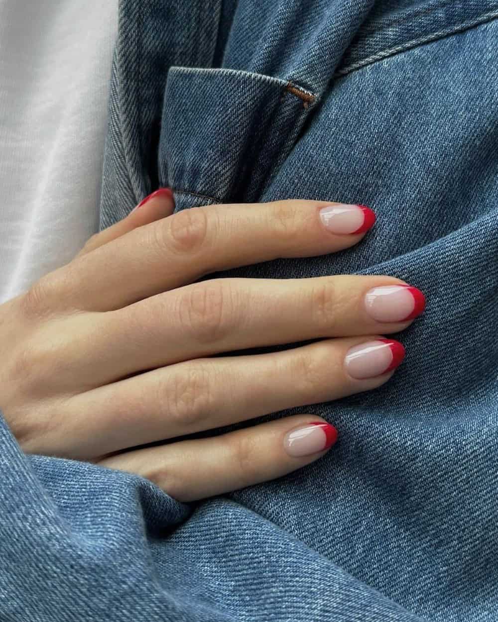 Short nails painted in a bold pop-art red hue