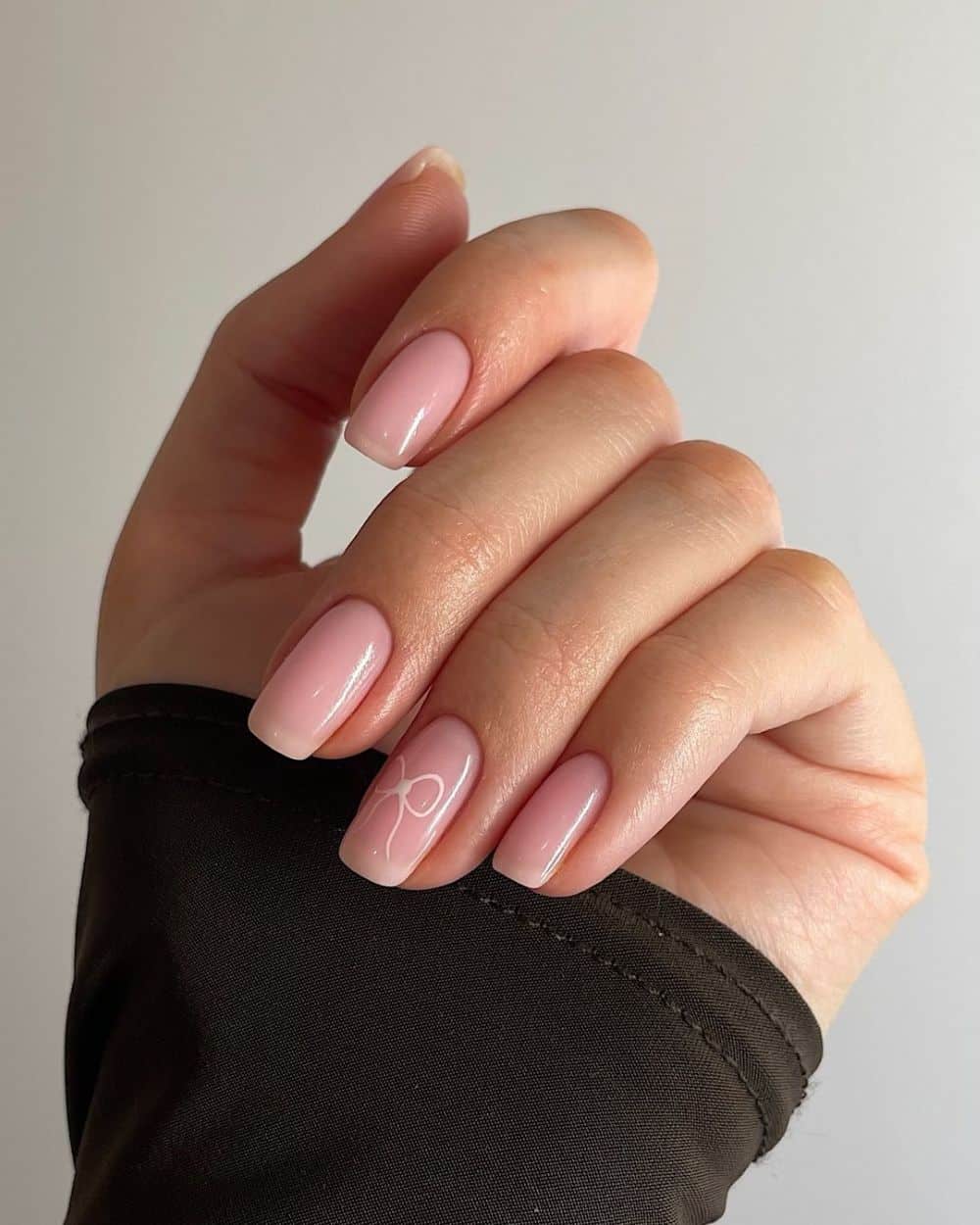 Sheer pink nails with subtle glitter accents