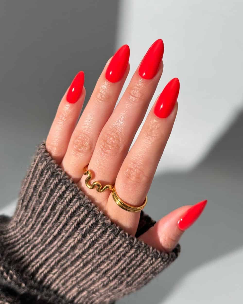 A single nail adorned with vibrant pop-art red polish