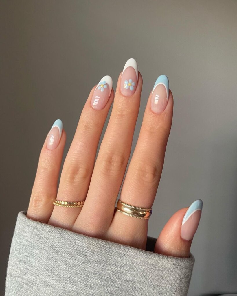 Baby blue French tips adorned with tiny floral designs.