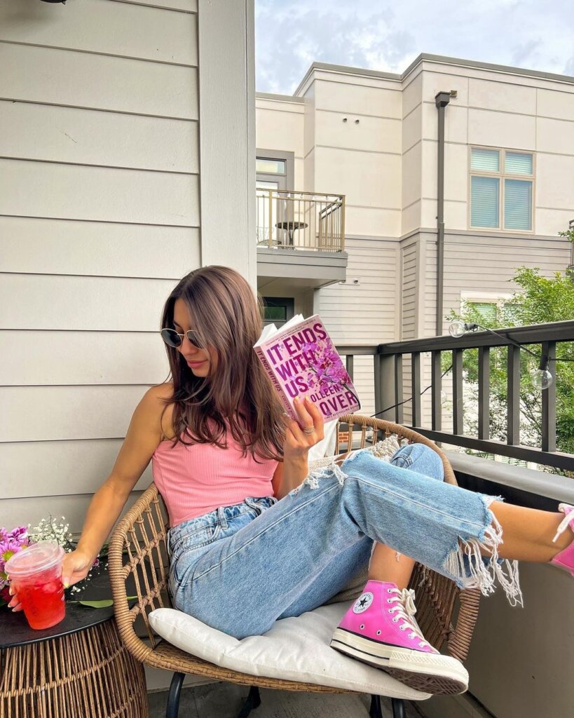 A pink tank top paired with relaxed denim and statement sneakers, conveying a comfortable and stylish off-duty spring look.