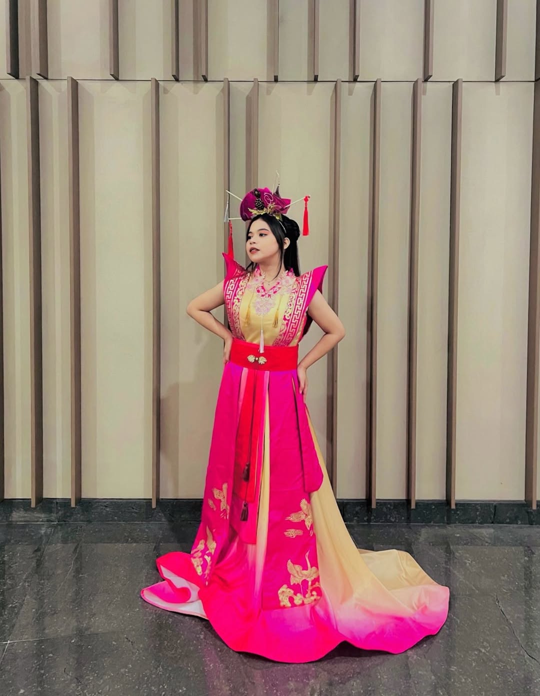 A woman wearing a brightly colored, dramatically shaped dress that makes a bold statement for Chinese New Year.