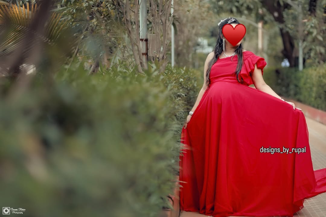 A woman in a vibrant red, flowing maternity gown.