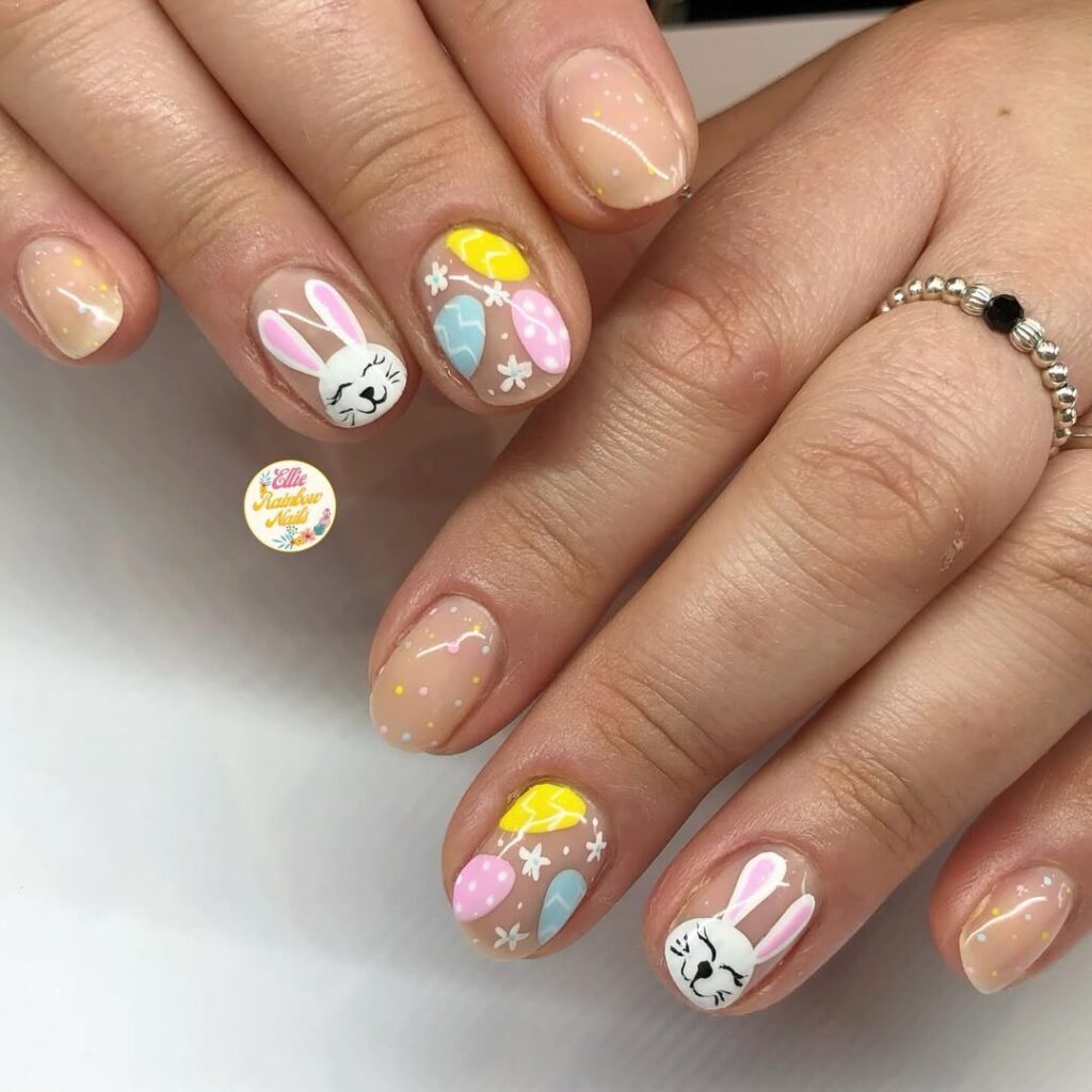 Cute Easter nail art featuring tiny bunnies and pastel eggs.