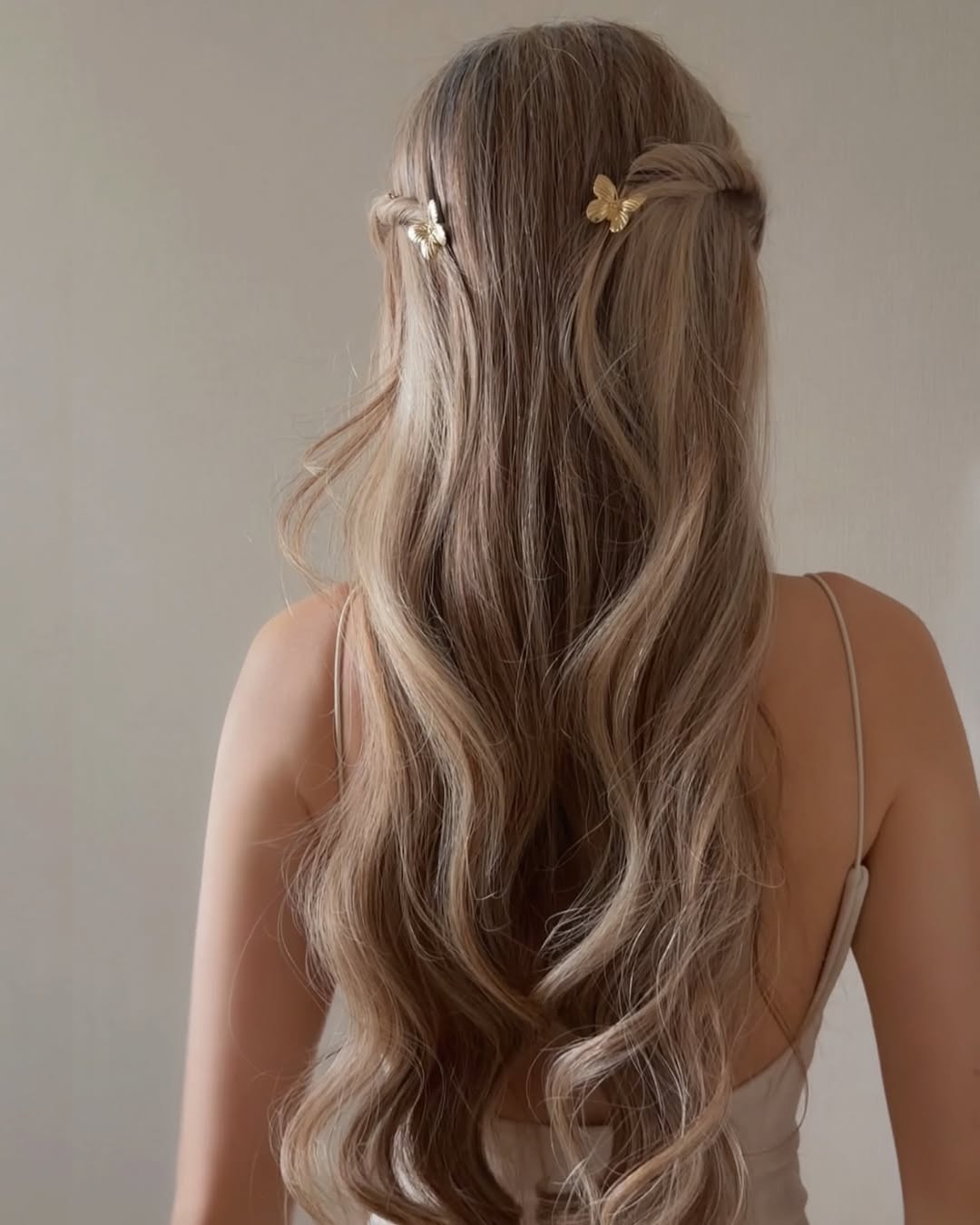 A half-up style featuring a playful butterfly clip.