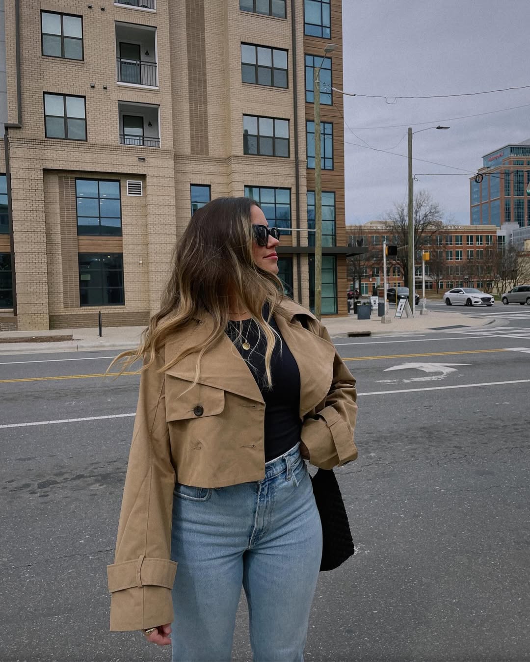 Wide-leg black pants, a cropped top, and a denim jacket create a strong yet relaxed city-ready spring outfit.