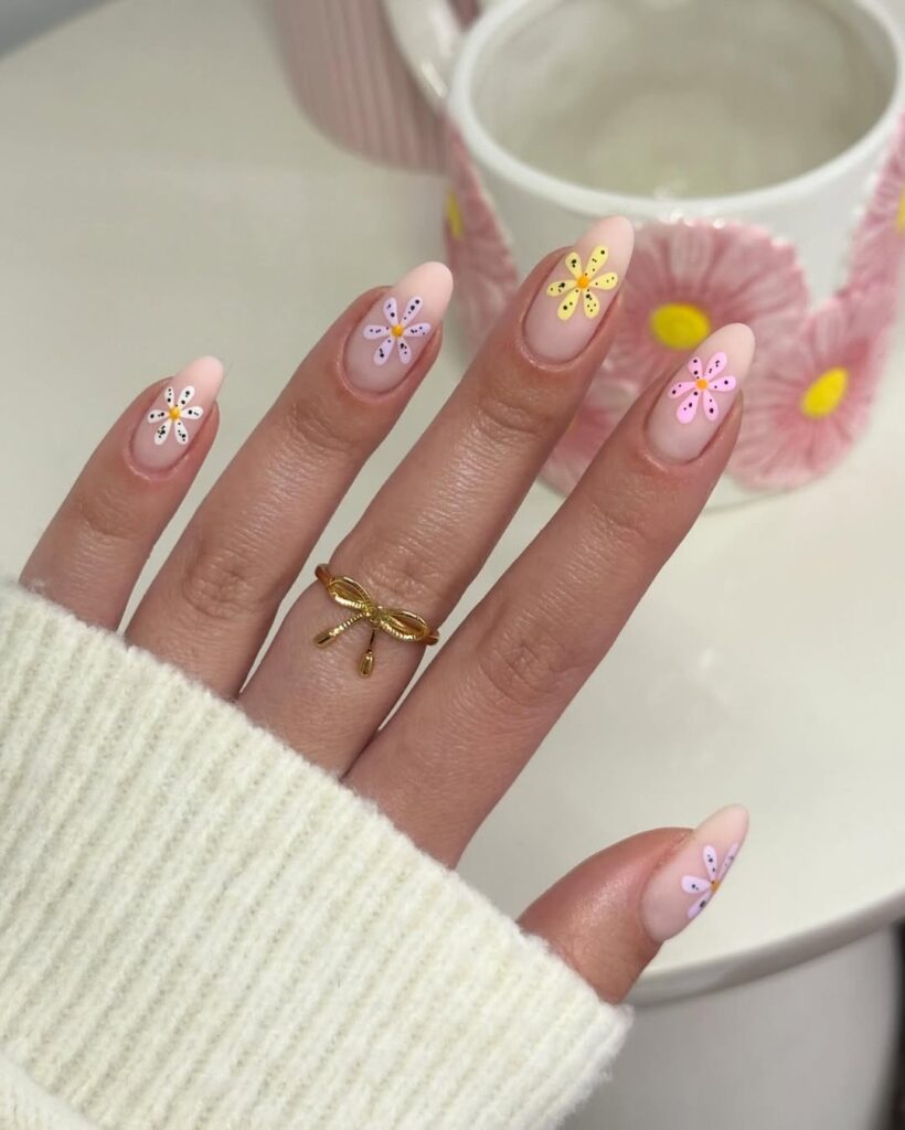 Soft pink nails with delicate floral patterns for a spring look.